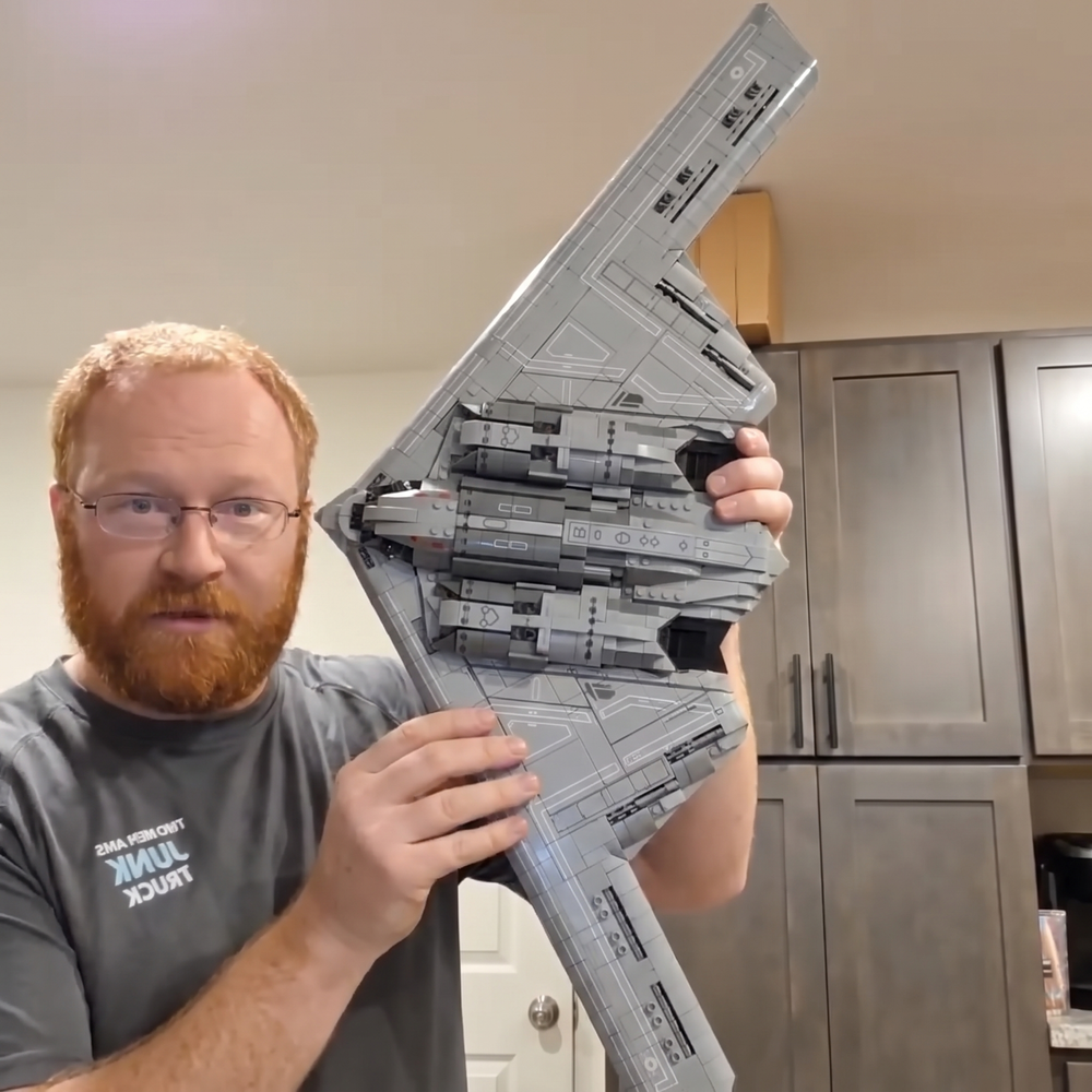 A builder holding the finished B-2 Spirit brick set, showing its size